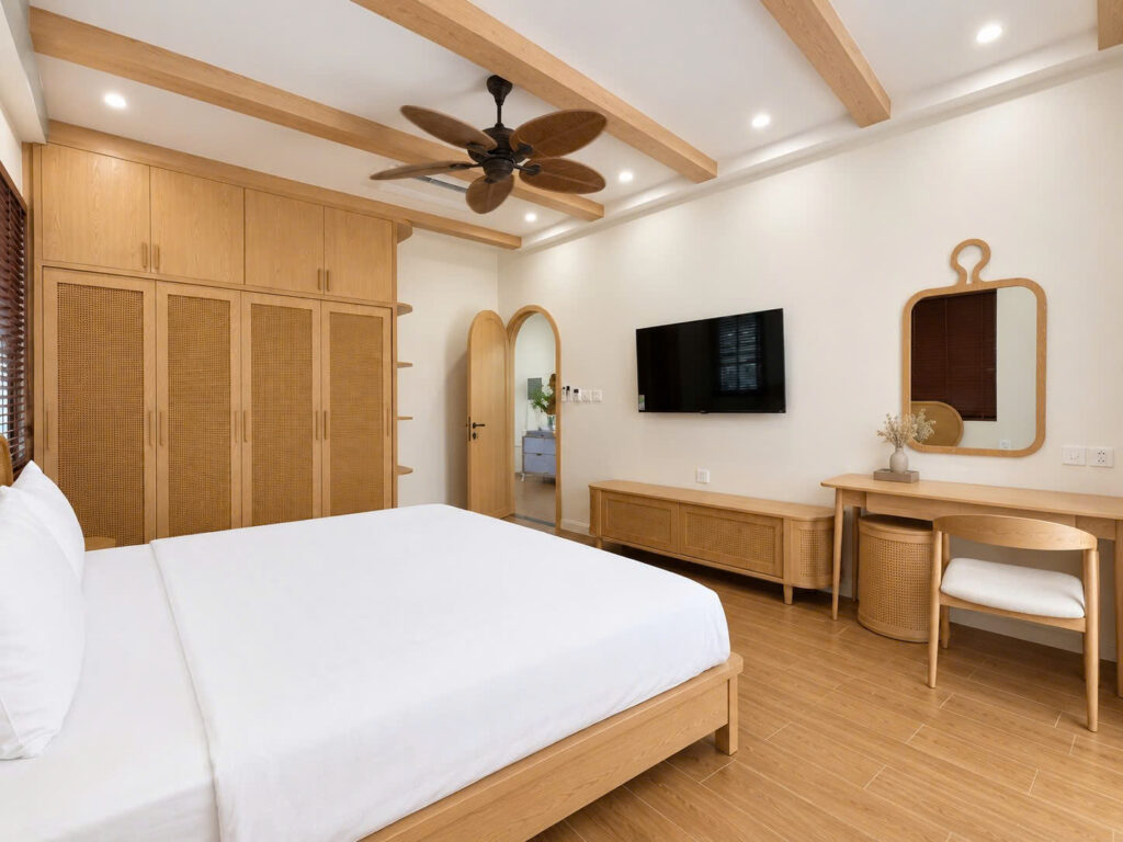Nội thất phòng ngủ master hiện đại với hệ tủ quần áo mây đan và bàn trang điểm gỗ do SMJA Home thiết kế