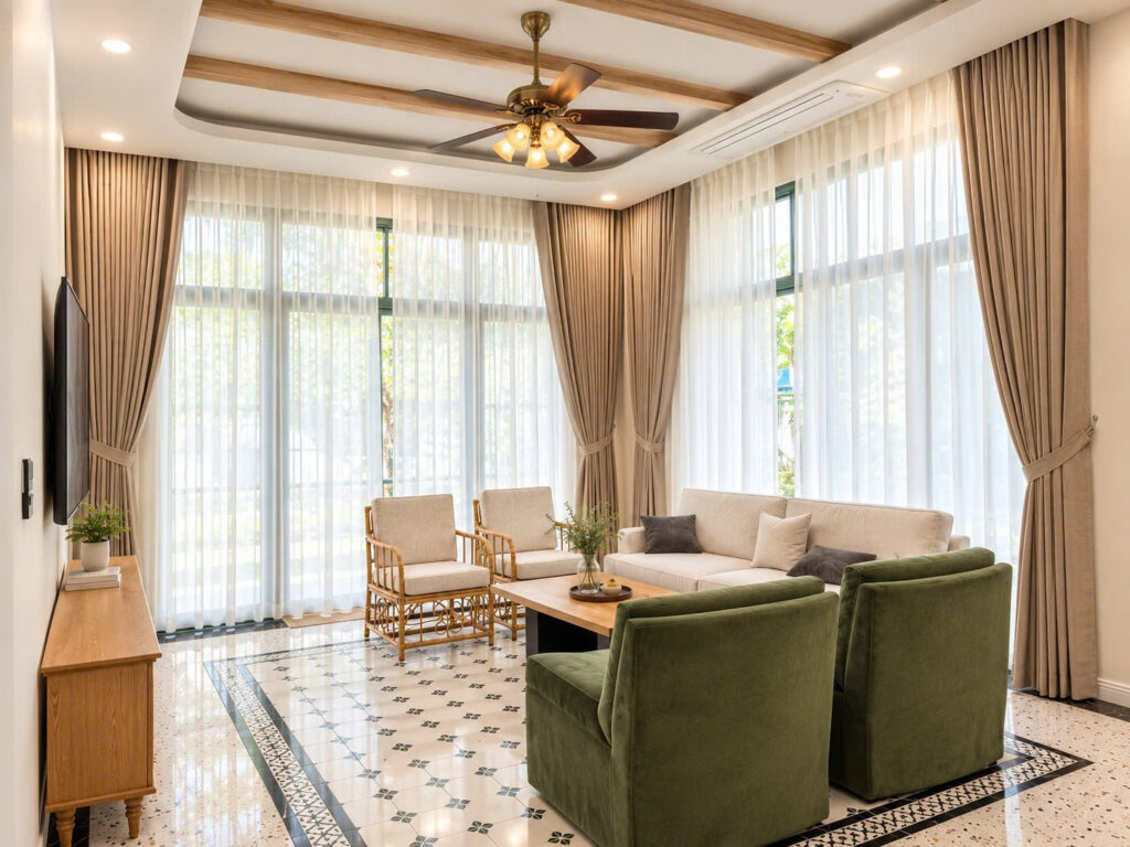 Phòng khách ngập tràn ánh sáng tự nhiên với hệ cửa kính lớn và rèm voan trắng tinh tế do SMJA Home thiết kế