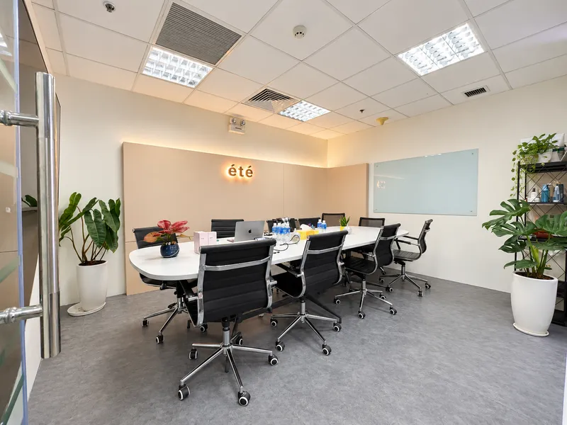 Phòng họp hiện đại và trang trọng tại văn phòng ÉTé với bàn họp lớn, ghế xoay thoải mái và bảng viết.